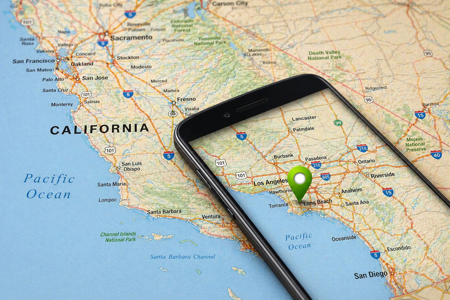 Phone over a California map with a green location pin near Hawthorne